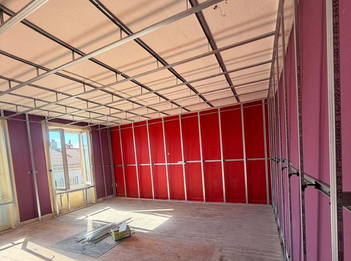 Travaux de placo sur une grande pièce en cours.